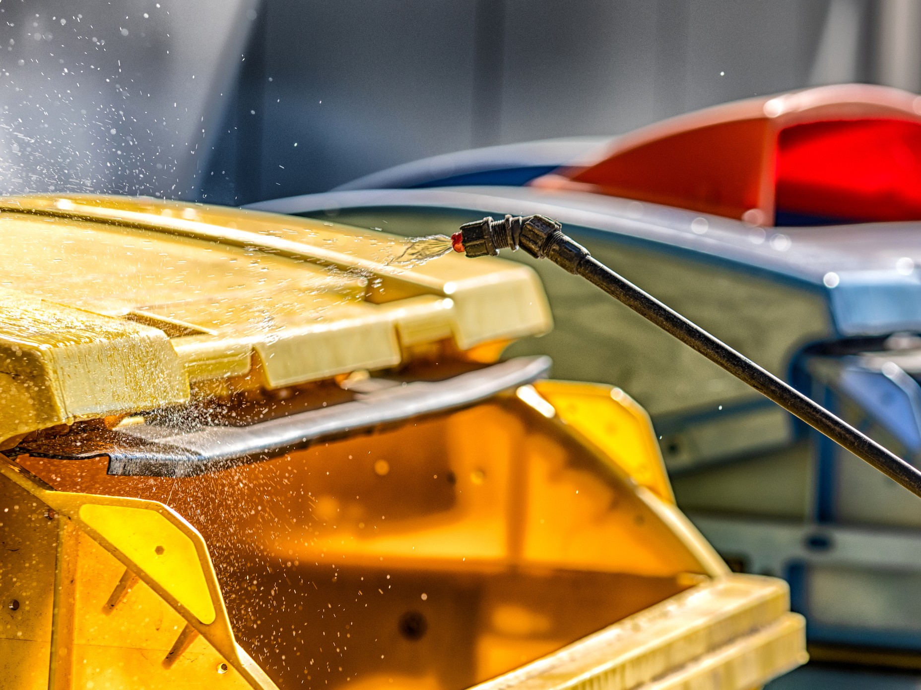 Pressure washing a large yellow bin